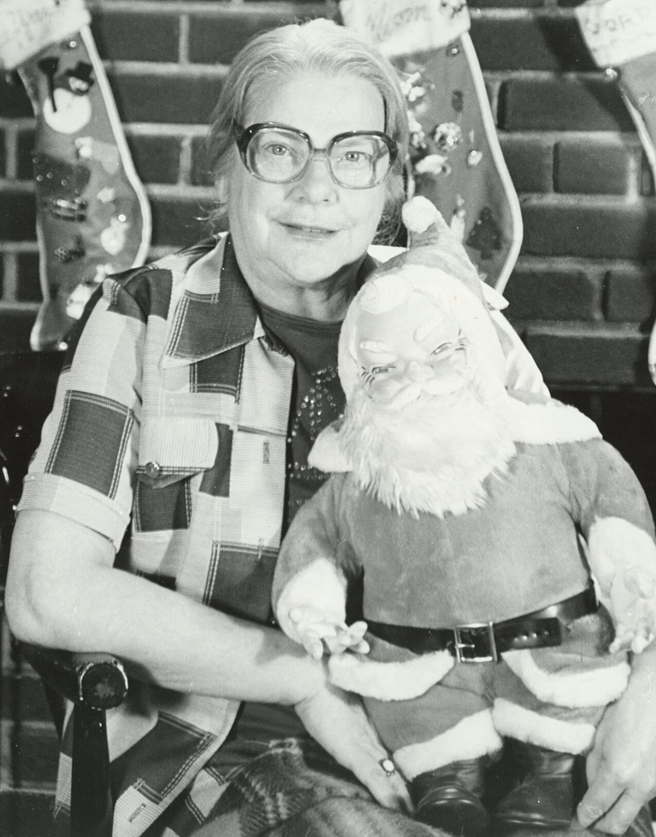 Mrs. Phyllis Kenneson pose with the largest Santa Claus in her collection of 175. This Santa stands 2 1/2 feet tall.